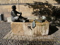 Ein Brunnen am Klosterplatz, der über die Schulter der Dame betrachtet werden muß.